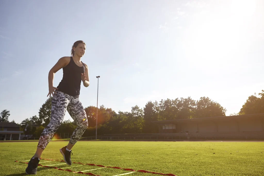 Active woman performing speed drills on grassy fie 2026 03 10 02 02 40 utc