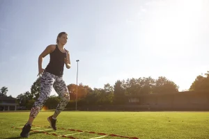 Active woman performing speed drills on grassy fie 2026 03 10 02 02 40 utc
